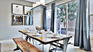 A dining area with a wooden table set for four, a bench, and a modern chandelier. - Entrada at Moab 424 and 428 (Moab)