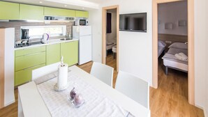 Una camera d'albergo compatta con angolo cottura, zona pranzo e un letto.