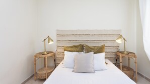 A bedroom with a bed, two bedside tables with lamps, a headboard, and a curtain. - Tranquil Coastal Escape, Porís de Abona (Porís de Abona)