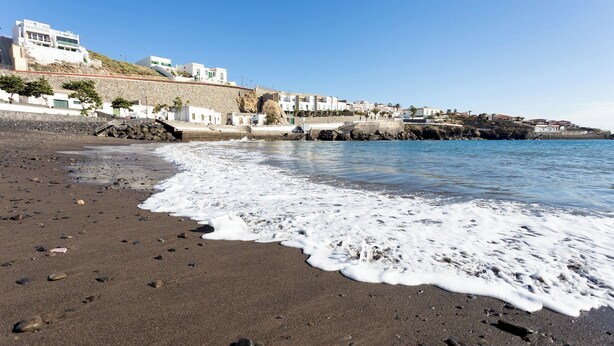 A beach with a rocky shoreline, waves, and buildings in the background. - Tranquil Coastal Escape, Porís de Abona (Porís de Abona)