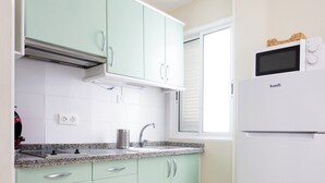 A kitchen with light green cabinets, a white refrigerator, and a granite countertop. - Tranquil Coastal Escape, Porís de Abona (Porís de Abona)