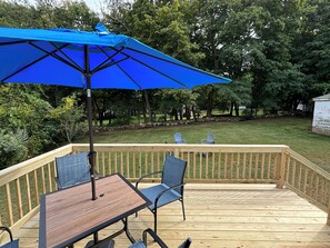 Relax on the deck with a comfortable seating area and a shaded table.