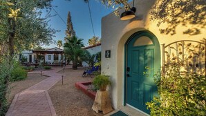 A courtyard with a blue door, a pergola, and a pool area. - Casita Sam Hughes/University King bed (Tucson)