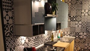 Una cucina compatta con lavatrice, lavello e un piano di lavoro con diversi oggetti.