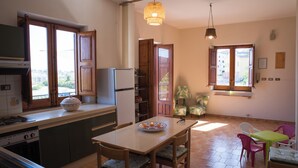 Una cocina con comedor, refrigerador, estufa y ventana con vistas.