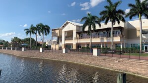 A multi-story hotel with balconies, a waterfront view, and palm trees. - Charming 3-bedroom rental less than 2 miles to Wellington Equestrian Festival (Wellington)