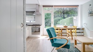 A modern kitchen with a gas stove, oven, and a large window overlooking a garden.