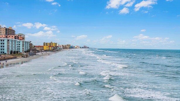 Un paisaje urbano costero con playa, edificios y el océano.