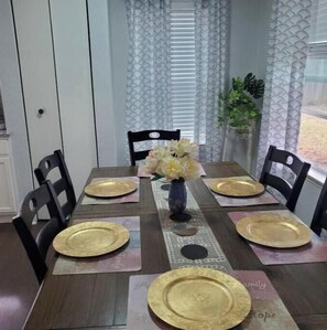 Enjoy meals in this stylish dining area with a table for four, adorned with a beautiful centerpiece and comfortable seating.