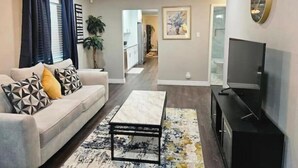 Un salon comprenant un canapé, une table basse, un téléviseur et un ventilateur de plafond.