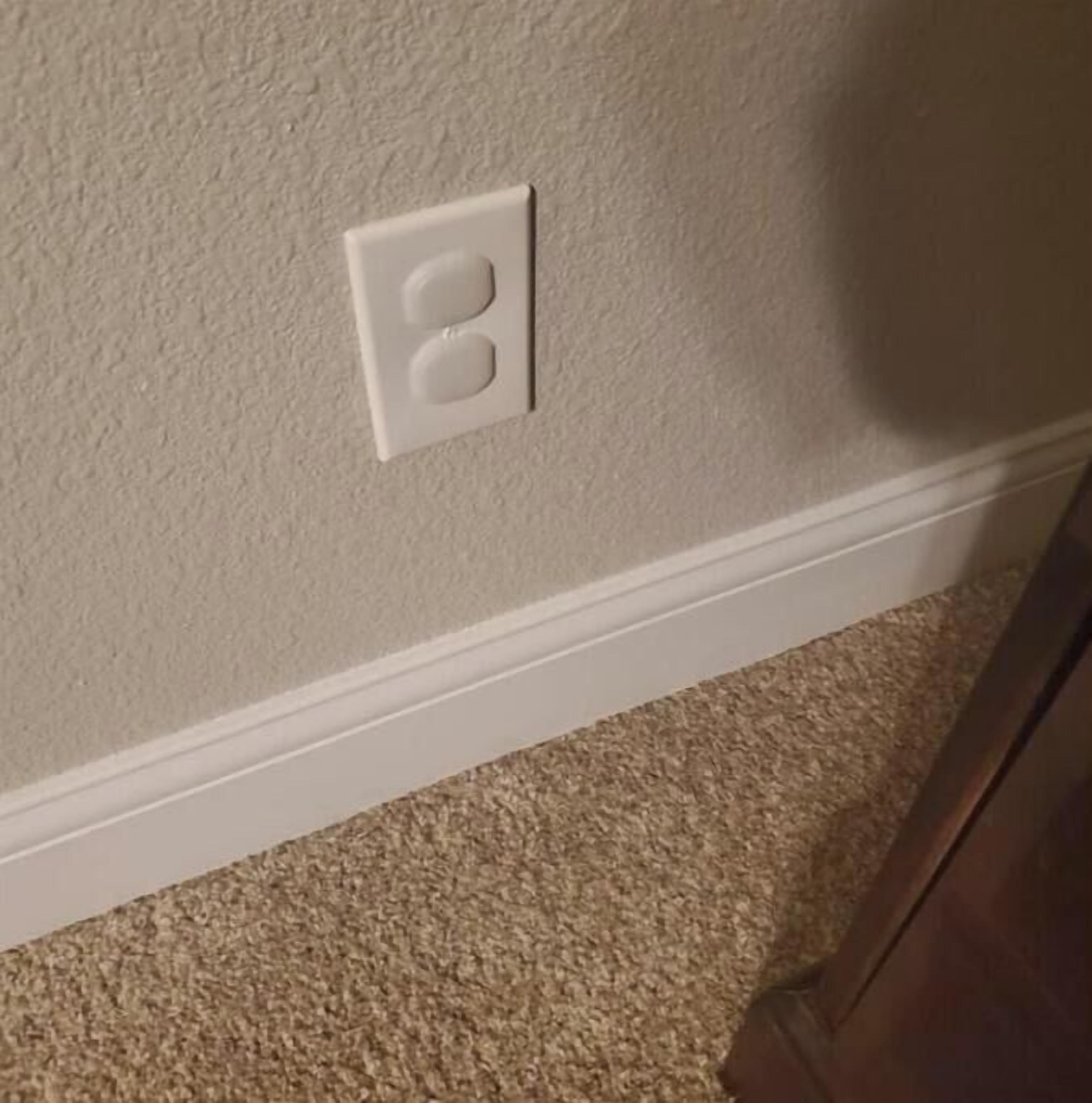 Eine weiße Steckdose an einer strukturierten Wand.
