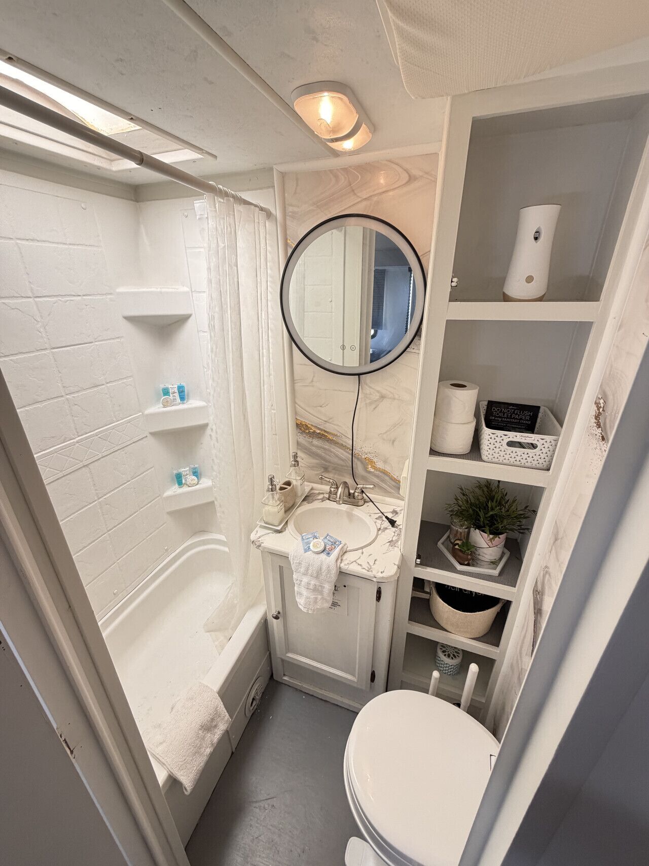 A compact bathroom with a bathtub, toilet, and sink.