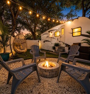 A recreational area with a fire pit, outdoor seating, and string lights. - “Charming RV Getaway – Close to everything! (Spring Hill)