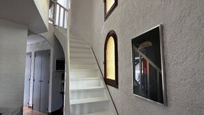 A staircase with white steps leading to a second floor, flanked by white walls and three arched windows. - Villa T4 type canétoise air-conditioned and near beach - 6ILEF56 (CANET PLAGE)