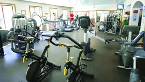 Une salle de sport équipée de vélos d’appartement, de tapis de course et d’autres appareils de musculation.