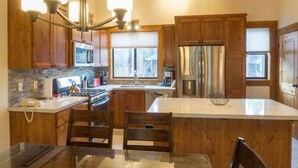 A modern kitchen with wooden cabinets, stainless steel appliances, and a large island.