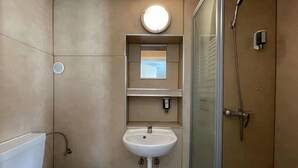 A modern bathroom with a toilet, a sink, a mirror, and a shower. - Interlaken Linda Inn Lodge (Interlaken)