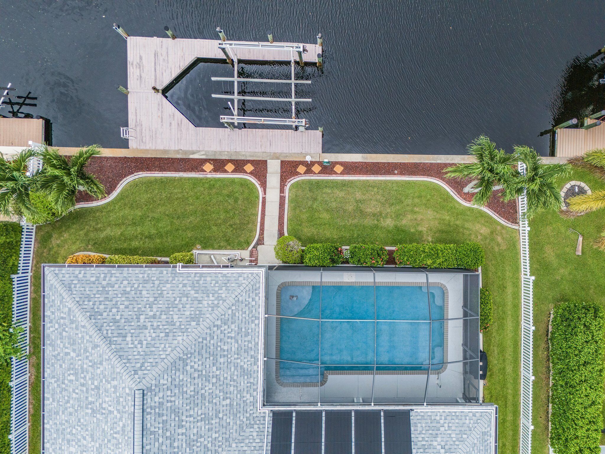 A rooftop pool with a surrounding deck and a small boat dock.
