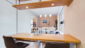 Una cucina moderna con piani in legno, due sgabelli da bar e un tavolo da pranzo.