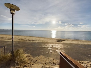 Une plage avec un lampadaire et une rambarde en métal.