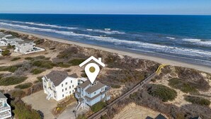 Propiedad frente a la playa con varias casas, una playa y una vía de tren.