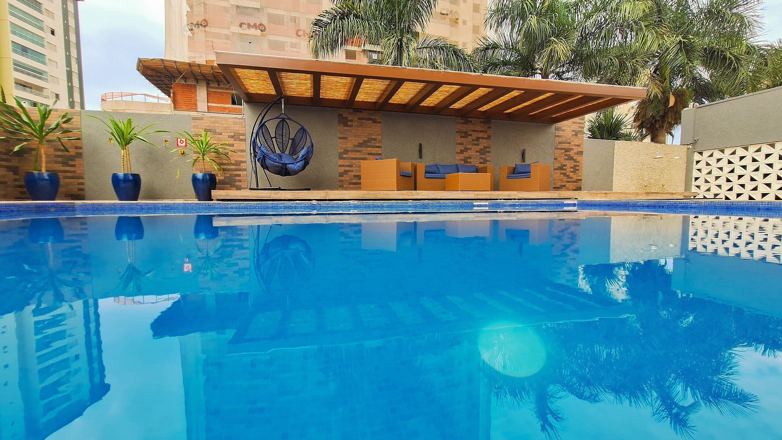 Una piscina al aire libre, sombrillas, sillones reclinables de piscina