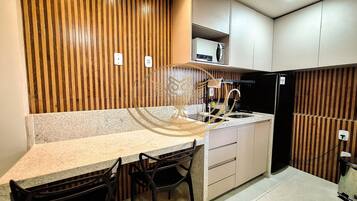 Grand Apartment | Private kitchen | Microwave, cookware/dishes/utensils, dining tables