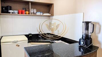 Departamento Deluxe | Cocina privada | Microondas, utensilios de cocina y comedor