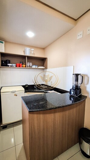 Departamento Deluxe | Cocina privada | Microondas, utensilios de cocina y comedor 