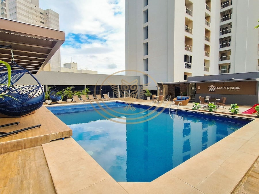 Una piscina al aire libre, sombrillas, sillones reclinables de piscina