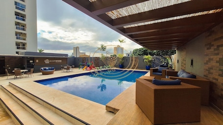 Outdoor pool, open 6:00 AM to 10:00 PM, pool umbrellas, pool loungers. Coruja Imob - Flat Crystal Place