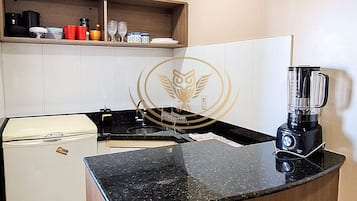 Apartamento básico | Cocina privada | Microondas, utensilios de cocina y mesa de comedor