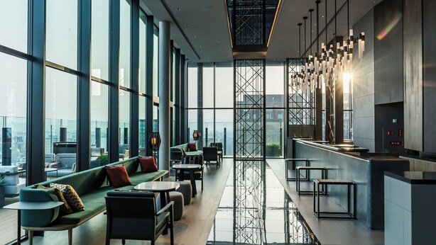 A modern interior with large windows, a central seating area, and a kitchen counter. - THE GATE HOTEL FUKUOKA by HULIC (Fukuoka)