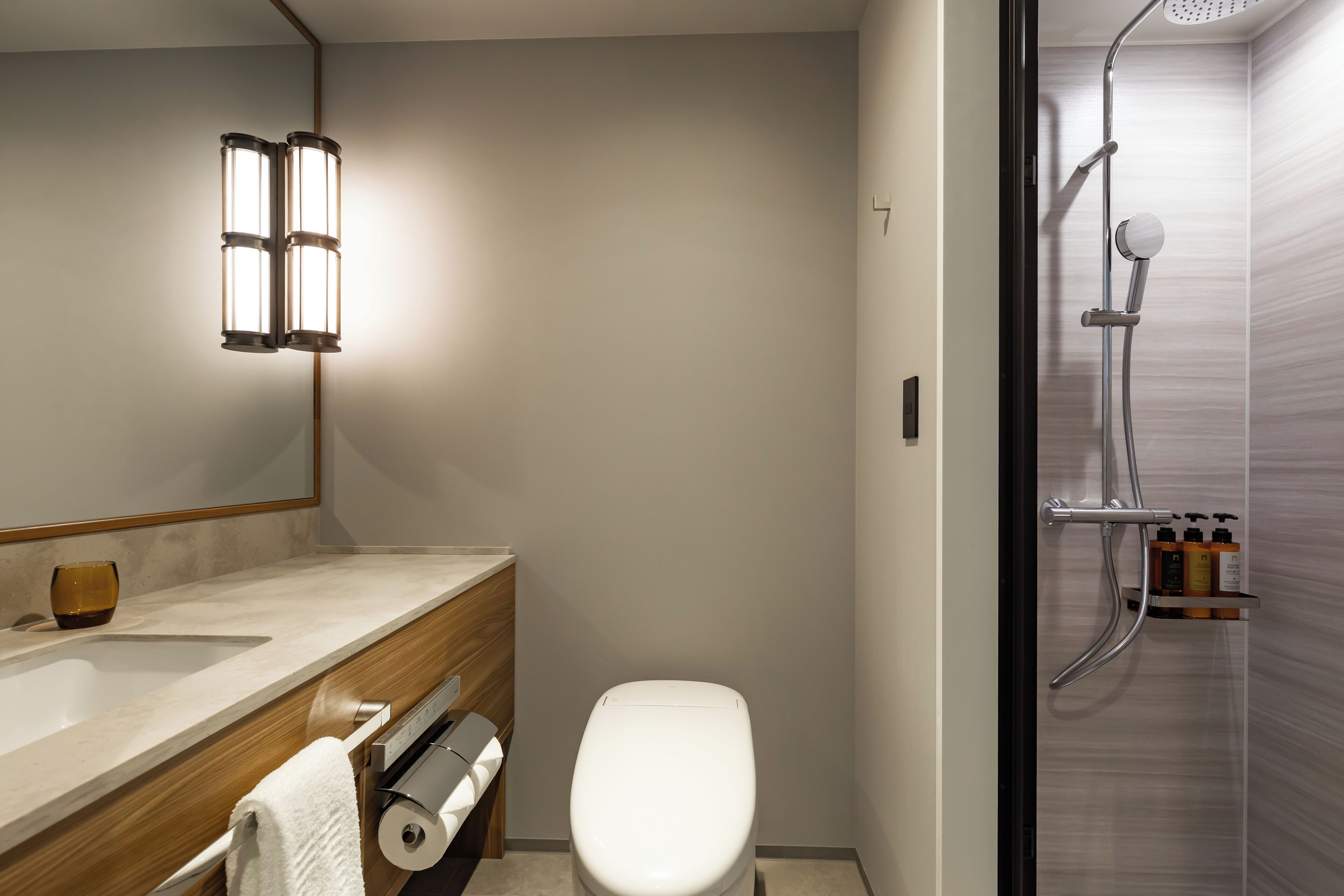 A modern bathroom with a toilet, sink, and shower.