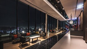A modern hotel lobby with a long corridor, seating areas, and large windows offering city views. - THE GATE HOTEL FUKUOKA by HULIC (Fukuoka)