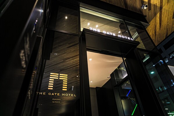 The entrance of The Gate Hotel with a modern design and illuminated signage. - THE GATE HOTEL FUKUOKA by HULIC (Fukuoka)