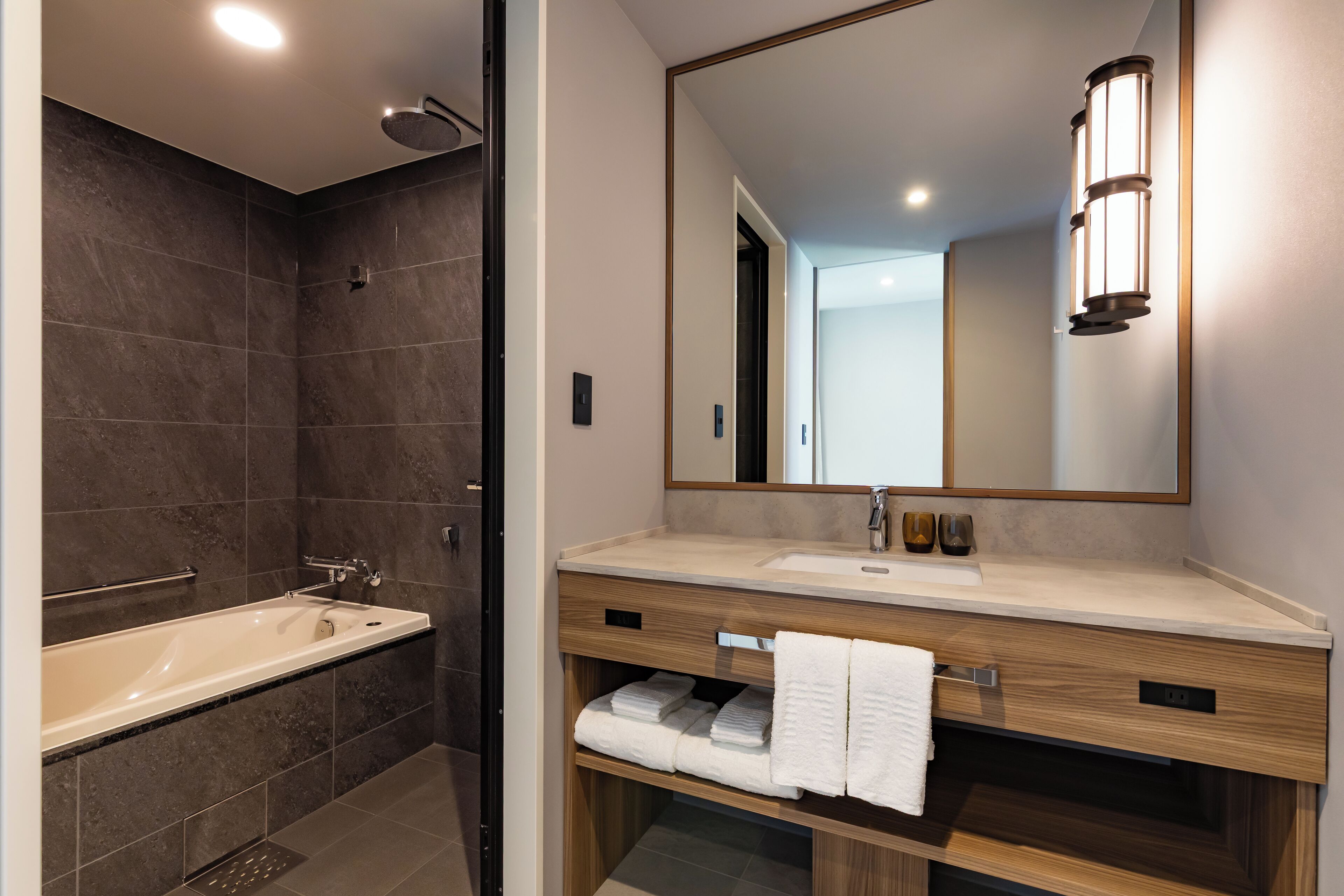 Un baño moderno con bañera, lavabo y espejo.
