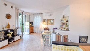 Un salon spacieux avec une cheminée, une bibliothèque et un coin repas.
