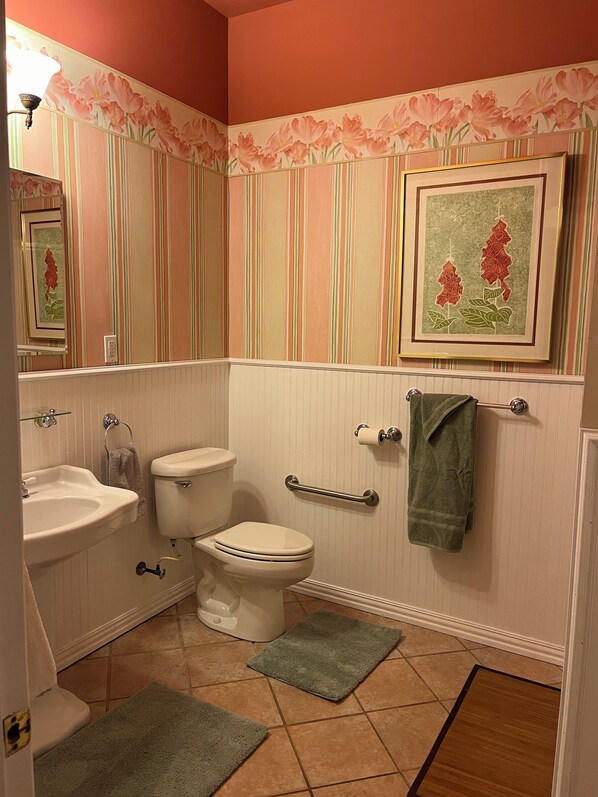 Ein Badezimmer mit Toilette, Waschbecken und Handtuchhalter.