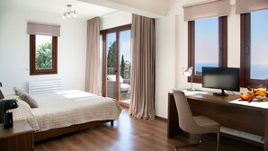 A hotel room with a bed, desk, and large windows offering a view of the outdoors. - Spectacular Sea Views Await, Paphos Villa 1481 (Paphos)