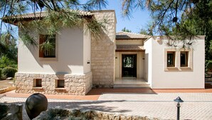 A two-story building with a stone facade, a tiled roof, and a paved entrance area. - Unwind in Luxury: Your Perfect Family Escape (Paphos)