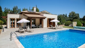 A modern house with a swimming pool, outdoor seating, and a covered patio area. - Unwind in Luxury: Your Perfect Family Escape (Paphos)
