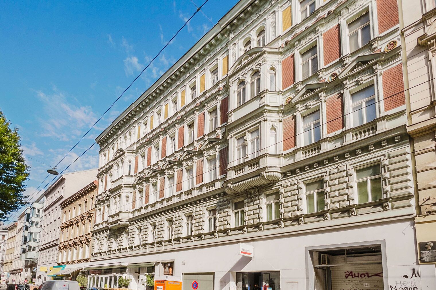 A row of historic buildings with ornate facades and large windows.