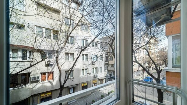 A view from a window overlooking a street with buildings and bare trees. - Varna Central Studio (Varna)
