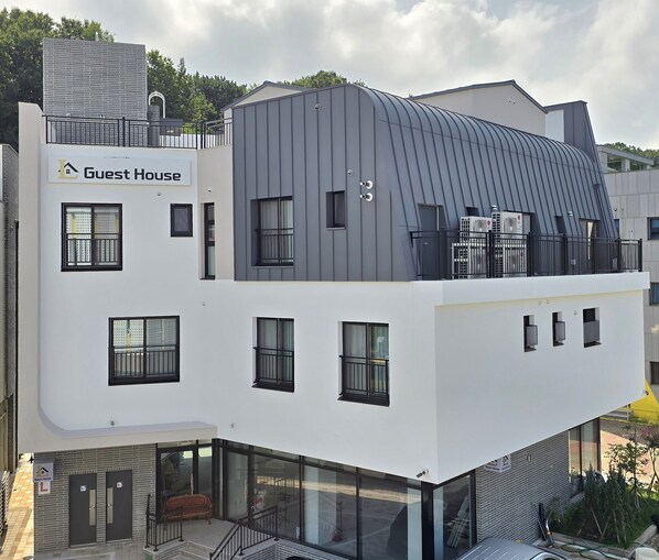 A modern building with a "Guest House" sign, large windows, and a flat roof. - Incheon Airport Guesthouse L (Incheon)