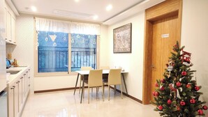 A modern kitchen with a dining table and chairs, a window with a view, and a Christmas tree. - Incheon Airport Guesthouse L (Incheon)