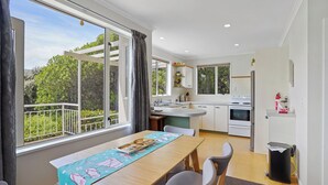 Une cuisine moderne avec un coin repas, de grandes fenêtres et un balcon.