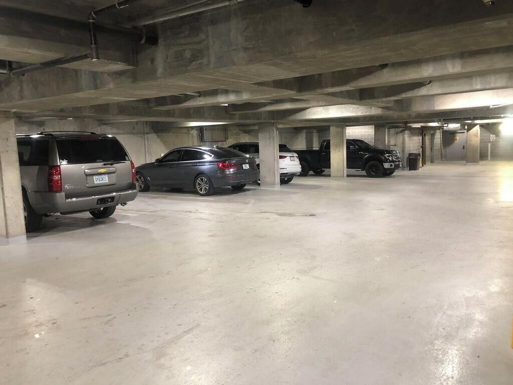 A multi-level parking garage with several cars parked in designated spaces.