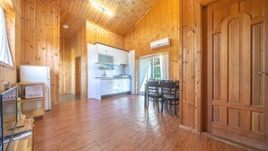 Een houten interieur met een keuken, een eethoek en een grote deur.