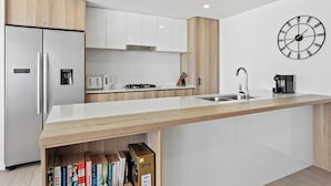 Eine moderne Küche mit Einbaukühlschrank, Kaffeemaschine und Spüle.
